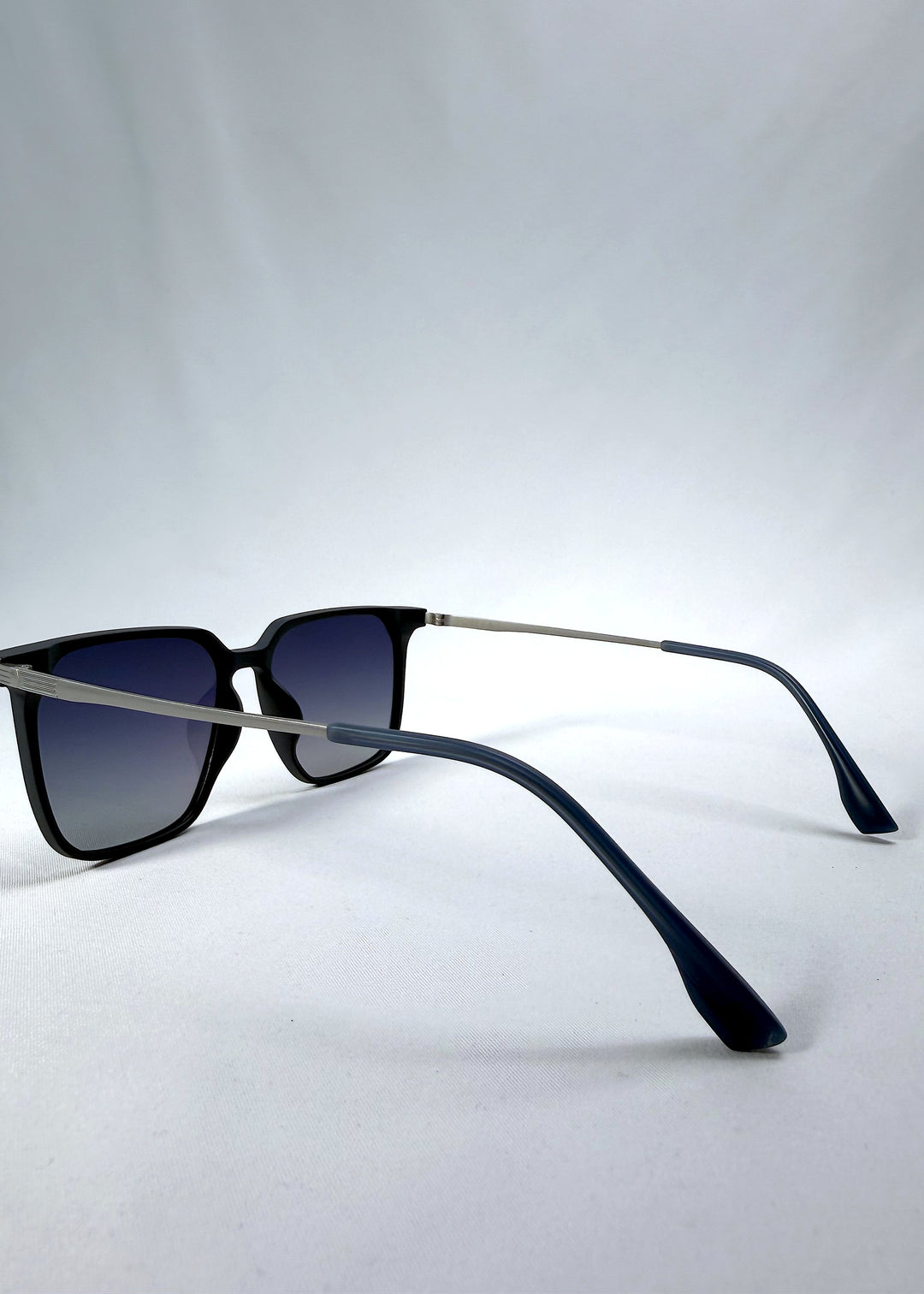 Side-angle view of Gemini sunglasses in Matte Blue, featuring light titanium frame, squared lens shape, and polarized lenses, showing the lens shape and temple profile.