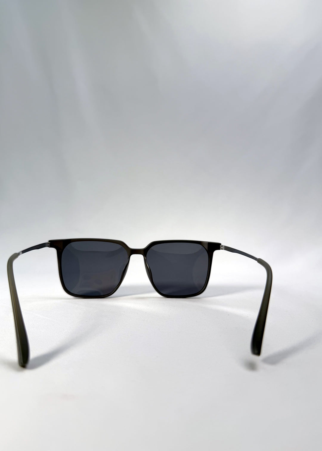 Back view of Gemini sunglasses in Matte Gray, featuring light titanium frame, squared lens shape, and polarized lenses, showing the inside frame and open temples.
