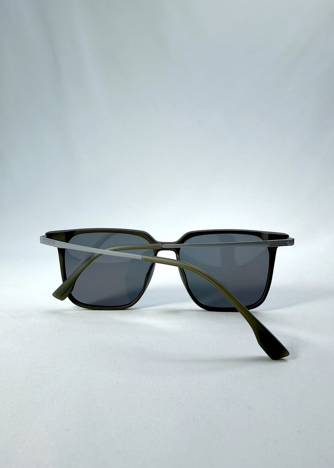 Folded view of Gemini sunglasses in Matte Gray, featuring light titanium frame, squared lens shape, and polarized lenses, showing the folded temples and frame profile.
