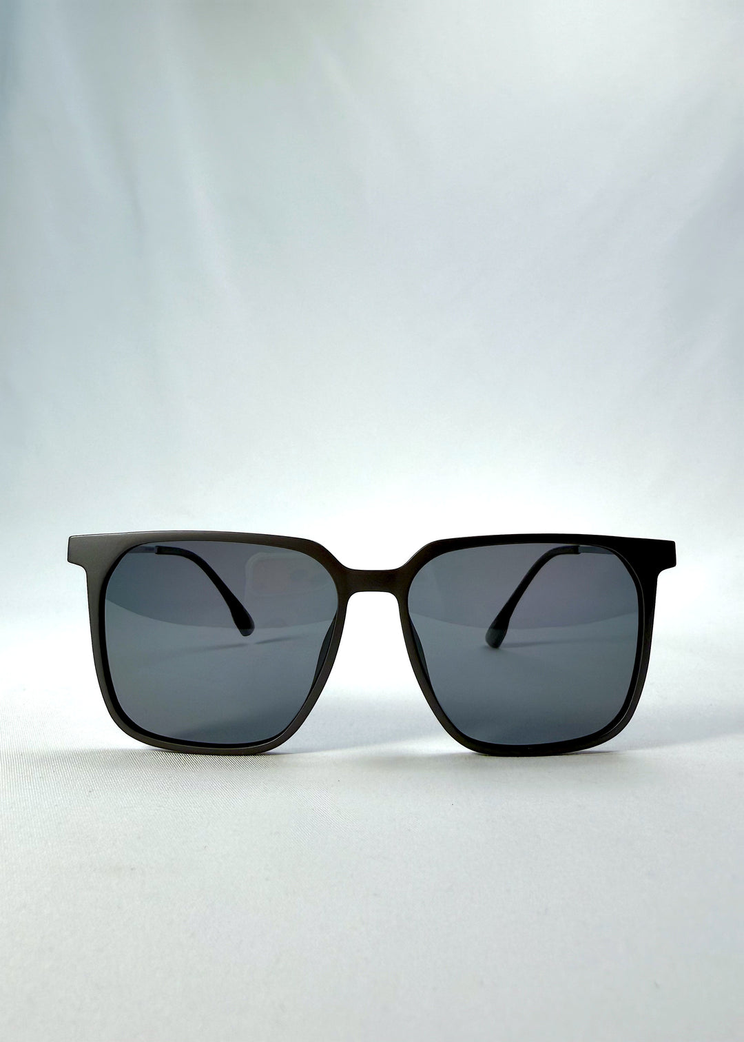 Front view of Gemini sunglasses in Matte Gray, featuring light titanium frame, squared lens shape, and polarized lenses, showing the full front silhouette.