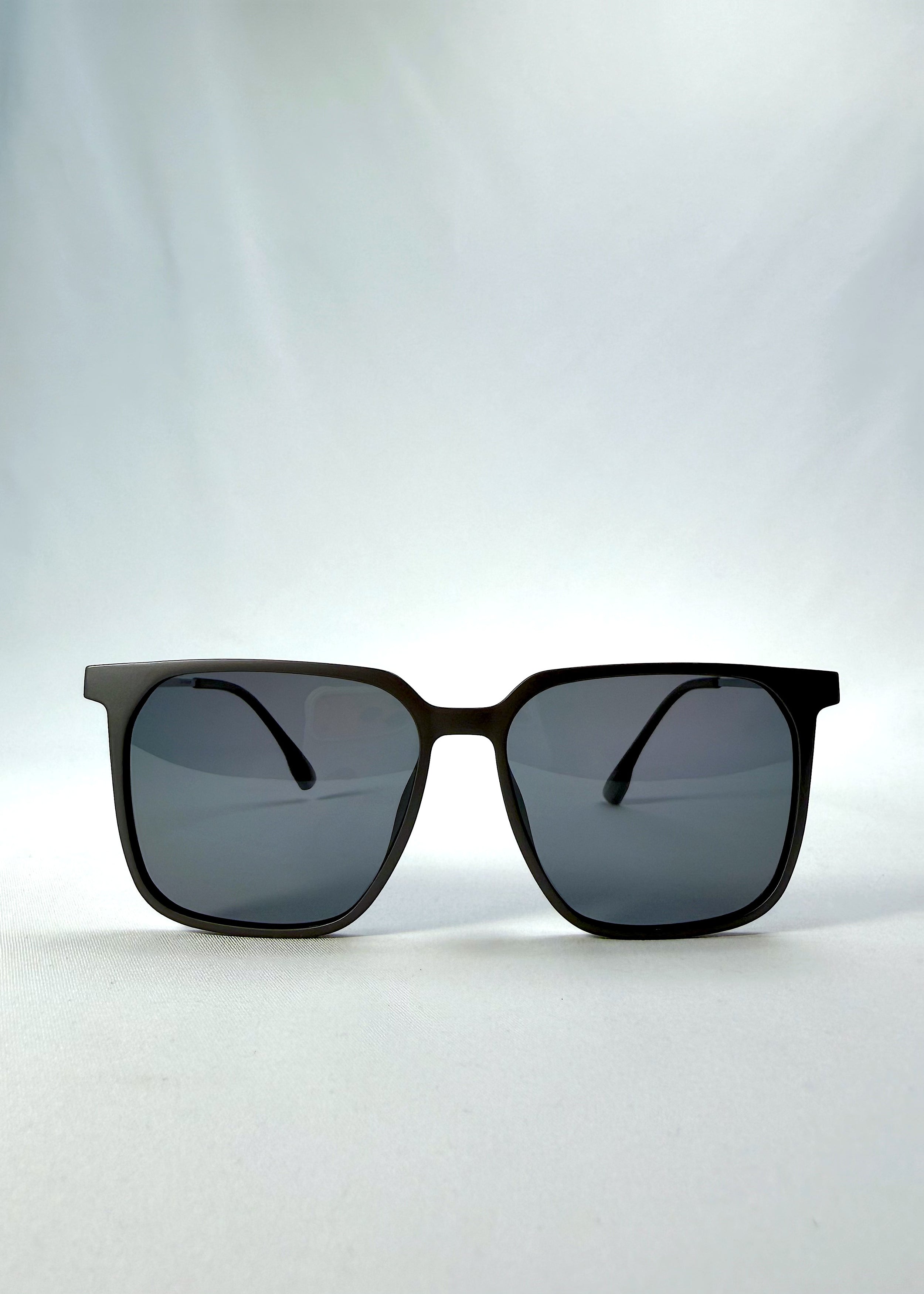Front view of Gemini sunglasses in Matte Gray, featuring light titanium frame, squared lens shape, and polarized lenses, showing the full front silhouette.
