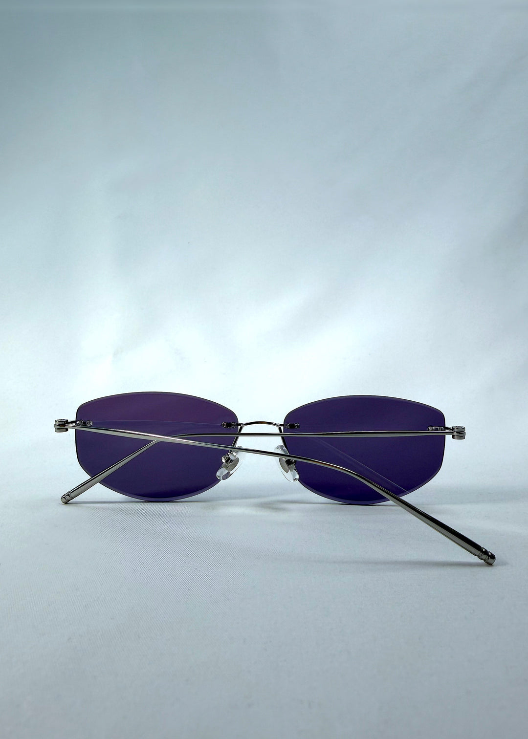 Folded back view of Halo Trace sunglasses in Glacial Blue, featuring blue-grey nylon lenses and a lightweight titanium frame, showing the folded temples and back structure.