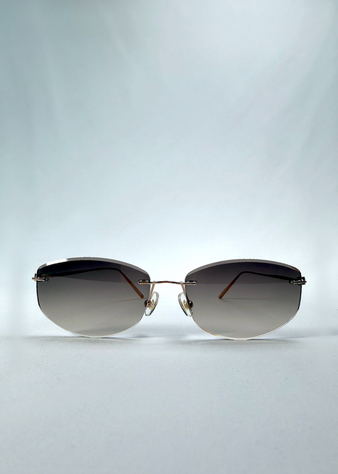 Front view of Halo Trace sunglasses in Gradient Amber, featuring rimless gold-tone frame and amber gradient lenses, showing the full front silhouette.