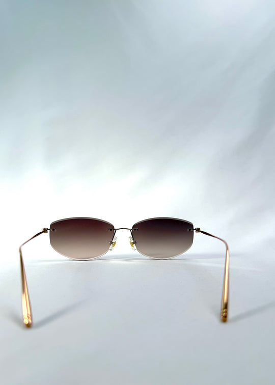 Back view of Halo Trace sunglasses in Verdant Halo, featuring green-to-rose gradient nylon lenses and a lightweight titanium frame, showing the inside frame and open temples.
