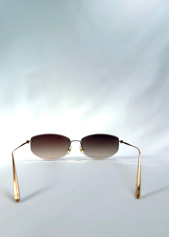 Back view of Halo Trace sunglasses in Verdant Halo, featuring green-to-rose gradient nylon lenses and a lightweight titanium frame, showing the inside frame and open temples. 