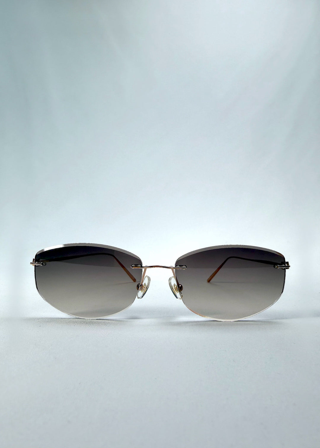 Front view of Halo Trace sunglasses in Verdant Halo, featuring green-to-rose gradient nylon lenses and a lightweight titanium frame, showing the full front silhouette. 
