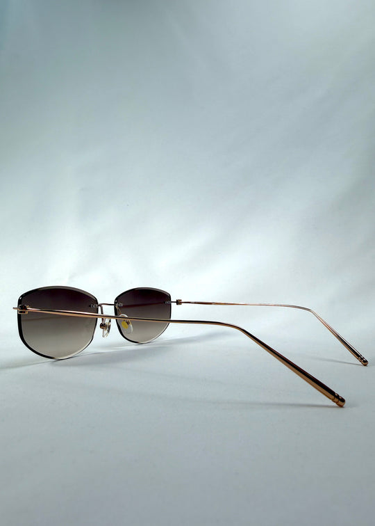 Side-angle view of Halo Trace sunglasses in Verdant Halo, featuring green-to-rose gradient nylon lenses and a lightweight titanium frame, showing the lens shape and side temple profile.