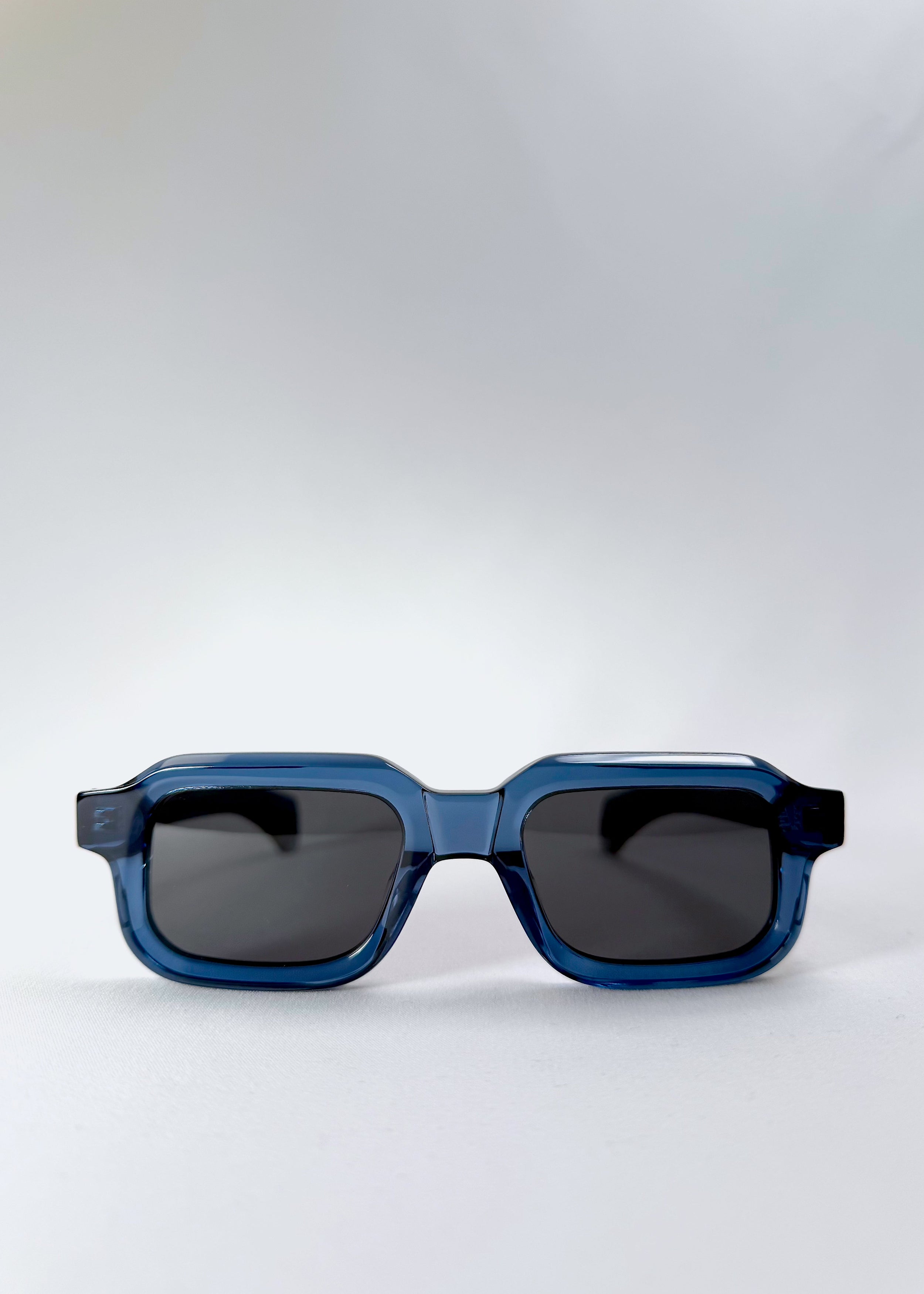 Front flat view of Havoc in Abyss Azure prescription sunglasses, highlighting the bold rectangular silhouette and smoky polarized lenses.