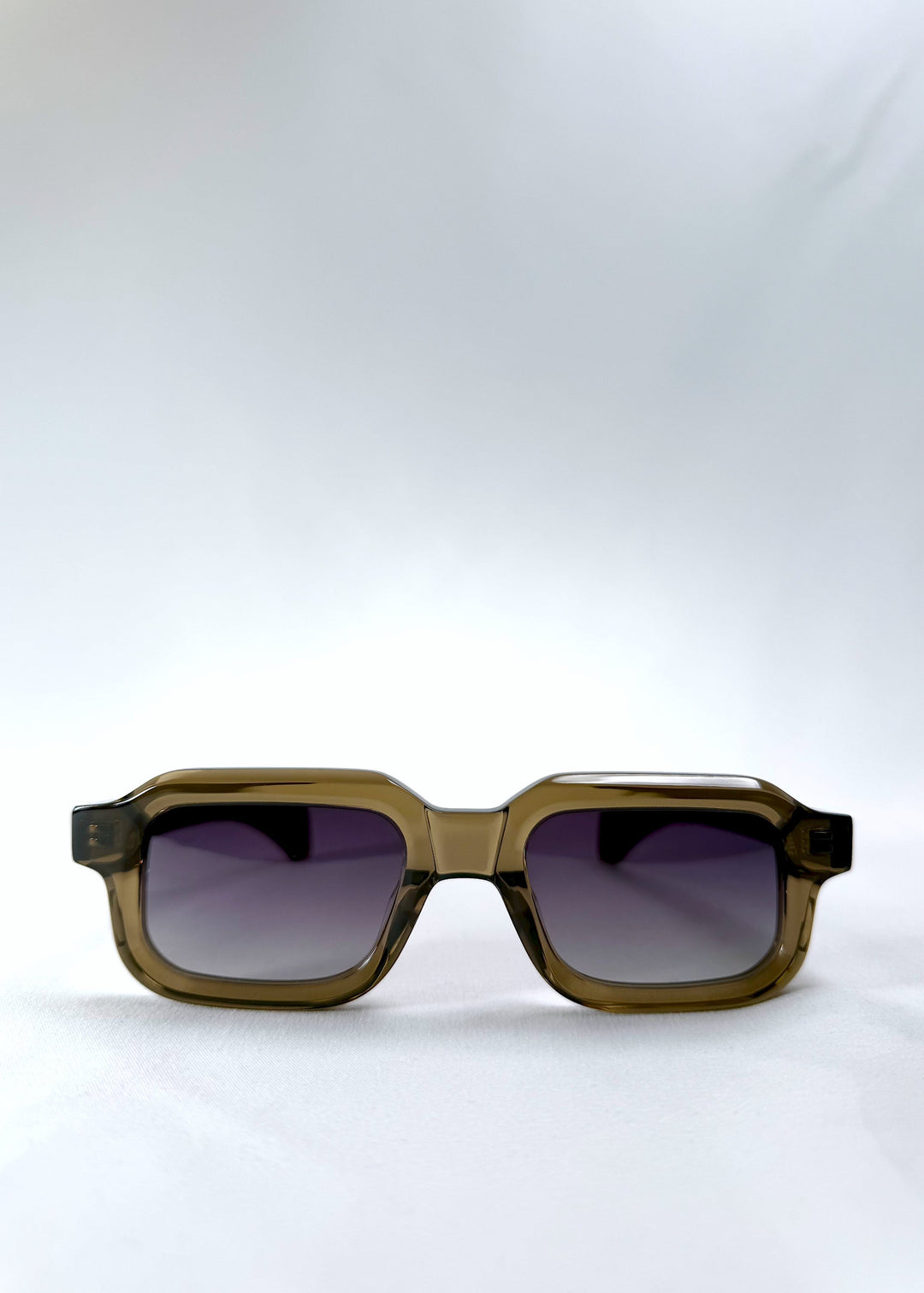 Front view of Havoc in Ember Fade, showing the bold rectangular frame in translucent olive green with violet-to-grey gradient lenses. 