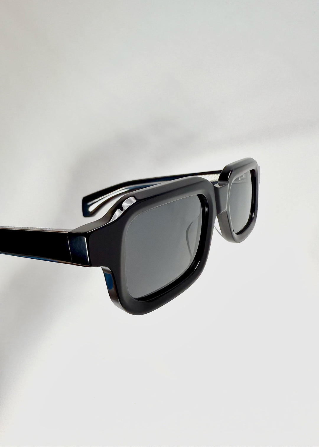 Angled close-up of Havoc in Obsidian Black, highlighting the bold frame contours and dark polarized lenses. 