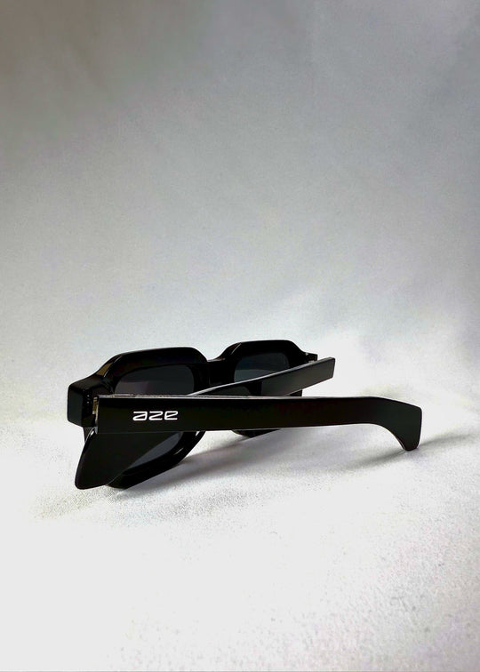 Havoc sunglasses in Obsidian Black folded neatly, revealing the compact design and Aze logo on the temple. 