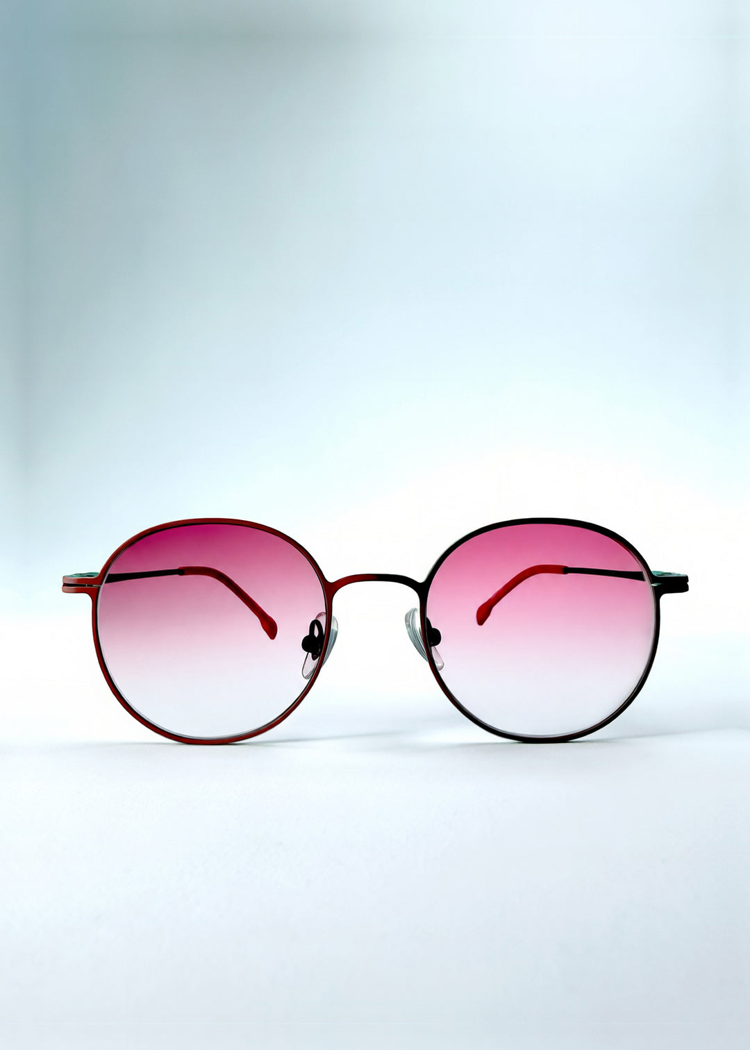 Front view of AZE Liora Arc sunglasses in Mauve Halo, featuring a green-accented round frame and pink gradient lenses, showing the full front silhouette.