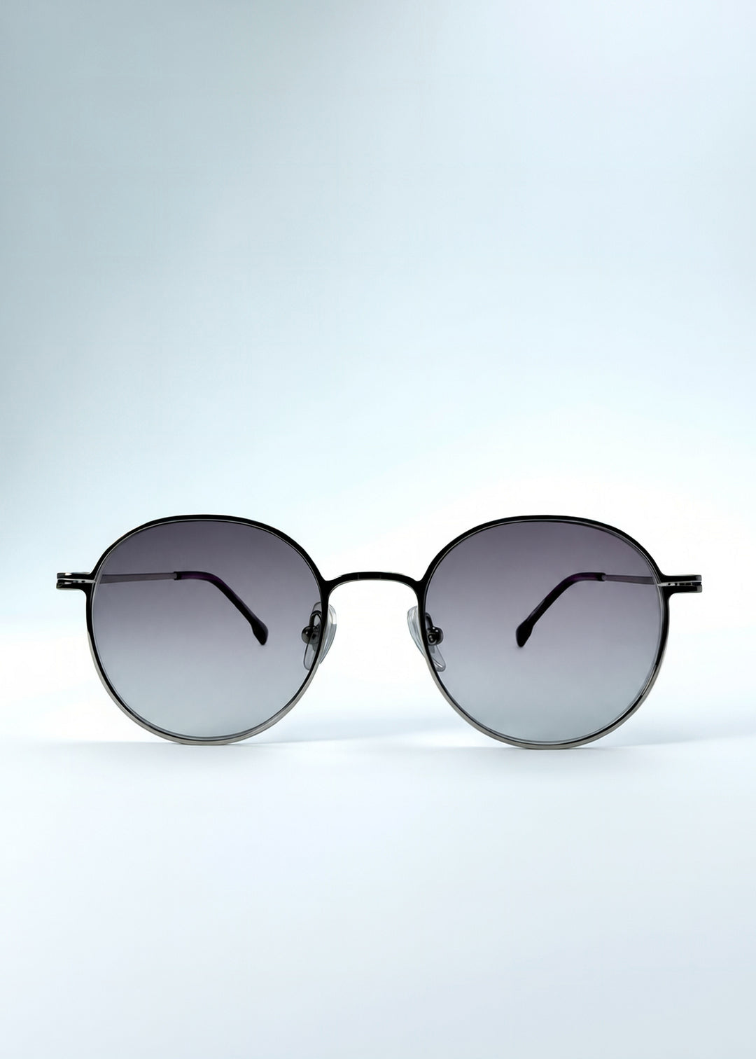 Front view of AZE Liora Arc sunglasses in Moonlit Silver, featuring a silver-tone round frame and gray gradient lenses, showing the full front silhouette.