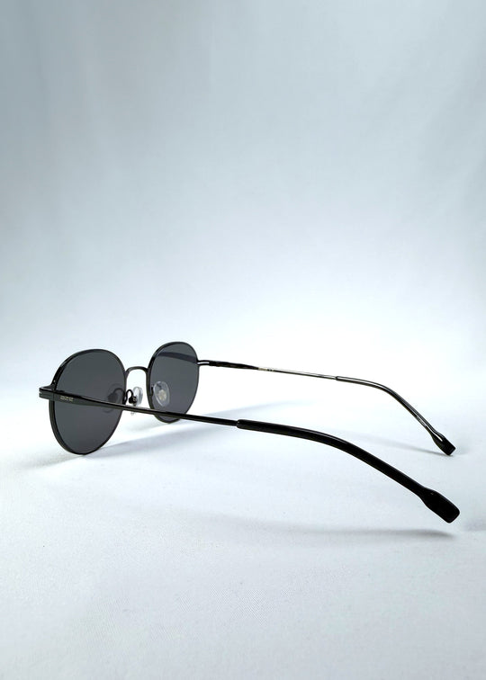 Back-angle view of AZE Liora Arc sunglasses in Obsidian Black, featuring a slim black round frame and smoky gray gradient lenses, showing the rear frame structure and temple alignment. 