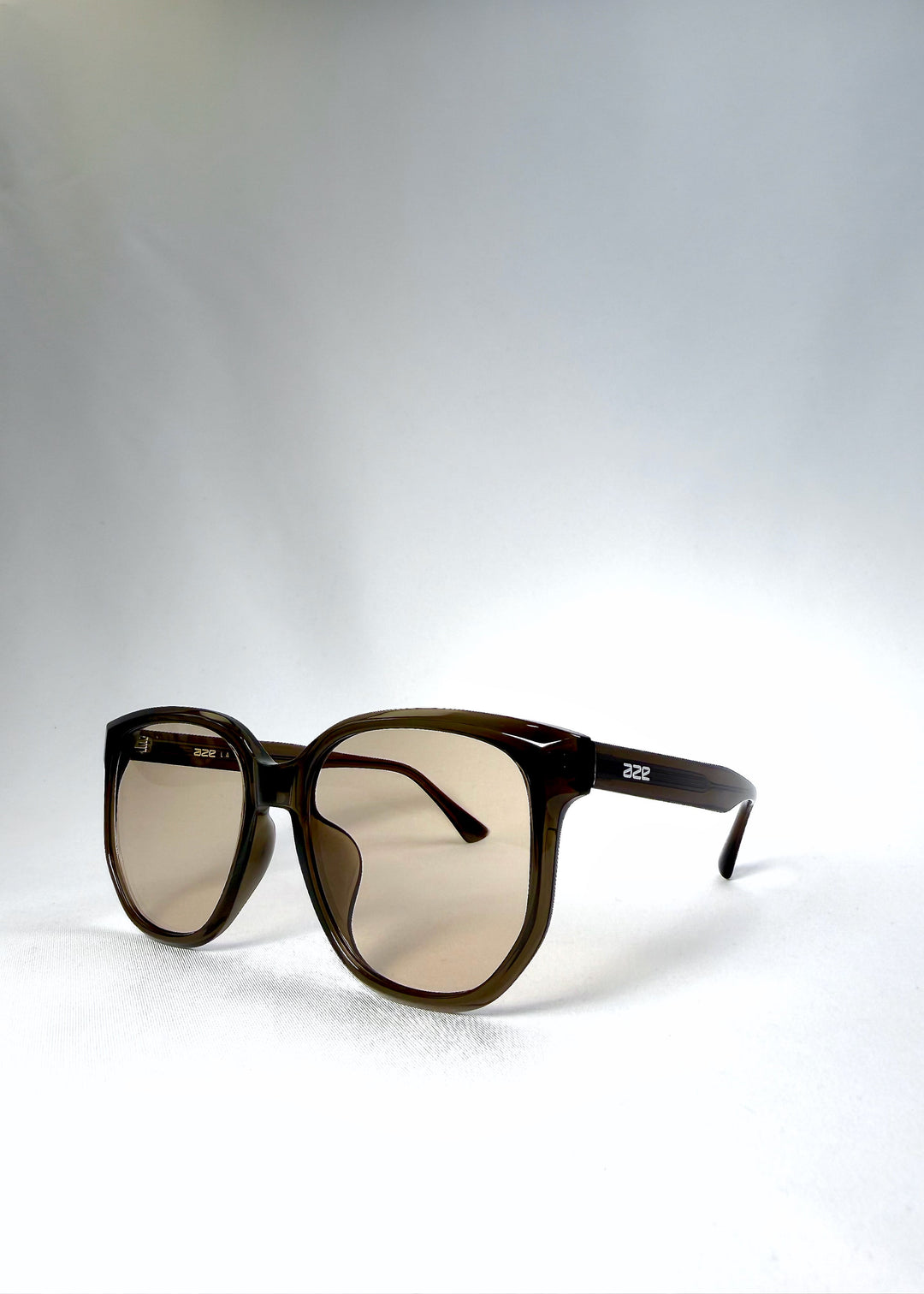 Angled front view of Lucent Rift in Sepia Veil highlighting the floating brow line and beige-brown lenses. 