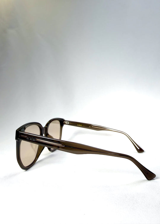 Side and temple view of Lucent Rift in Sepia Veil showing the subtly angular arms and translucent grey-tea frame. 