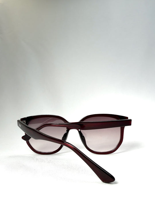 Folded view of Lucent Rift in Velvet Eclipse with arms crossed over the gradient plum lenses. 