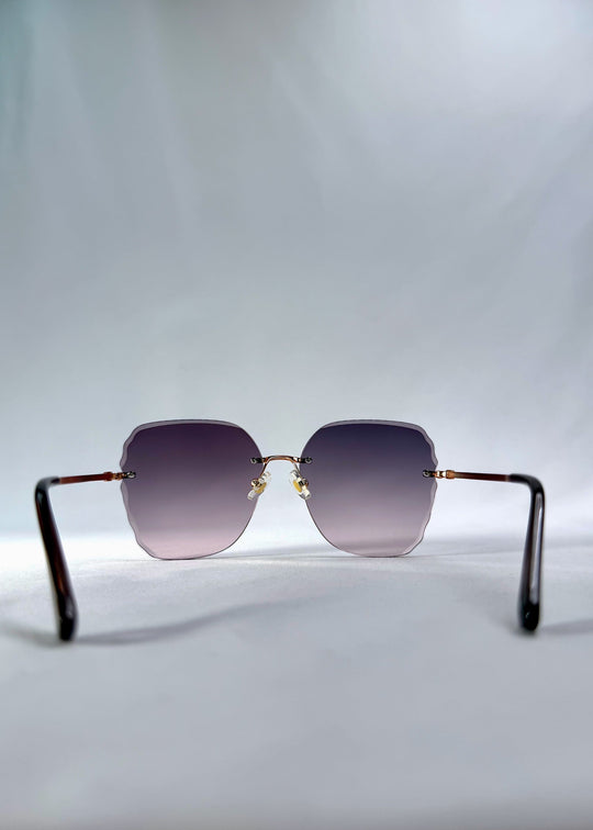 Back view of Lucera sunglasses in Misty Rosé, featuring rimless gold-tone frame and misty rose gradient lenses, showing the inside frame and open temples. 