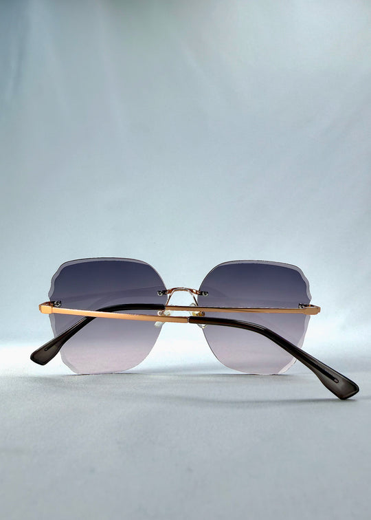 Folded back view of Lucera sunglasses in Misty Rosé, featuring rimless gold-tone frame and misty rose gradient lenses, showing the folded temples and back structure.
