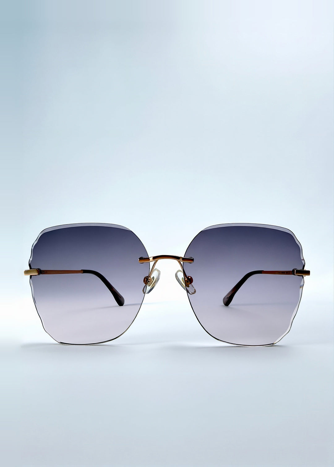 Front view of Lucera sunglasses in Misty Rosé, featuring rimless gold-tone frame and misty rose gradient lenses, showing the full front silhouette. 