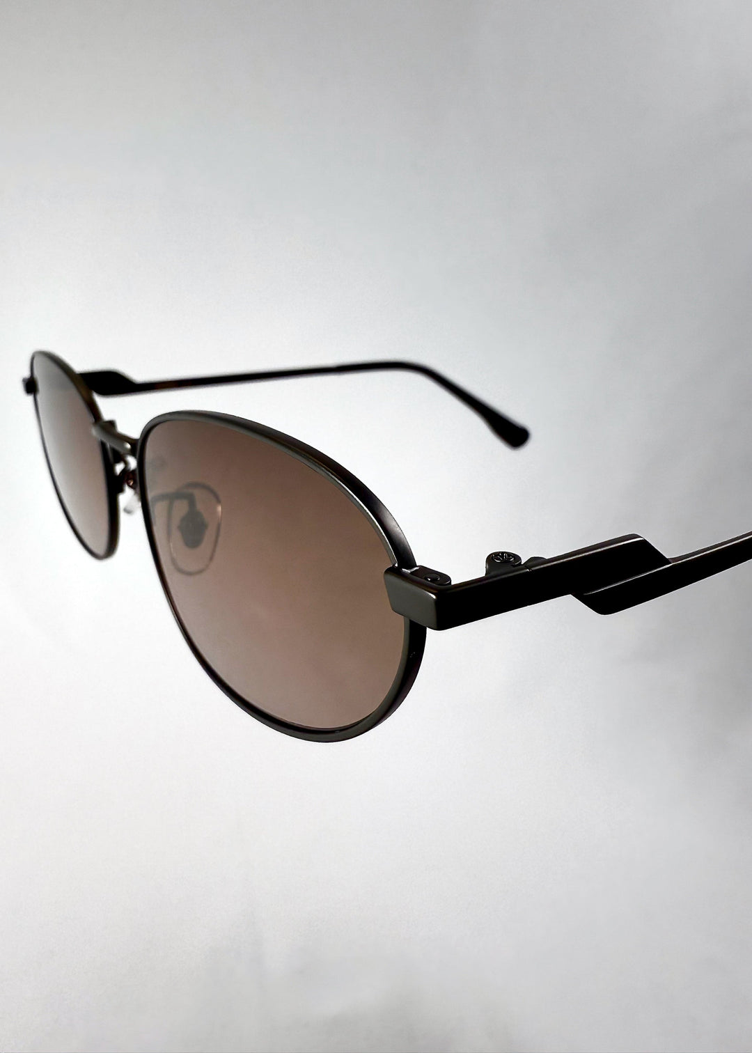 Close-up of Lunaris - Dusk Bronze lenses, featuring the gradient tea tint and smooth lens curvature. 