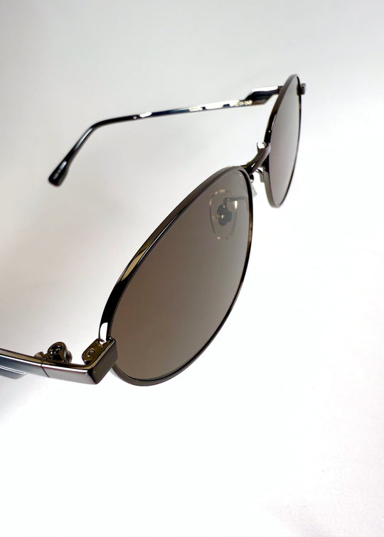 Detailed view of the lens and frame junction on Lunaris - Iron Ember, highlighting the frame finish and lens curvature. 