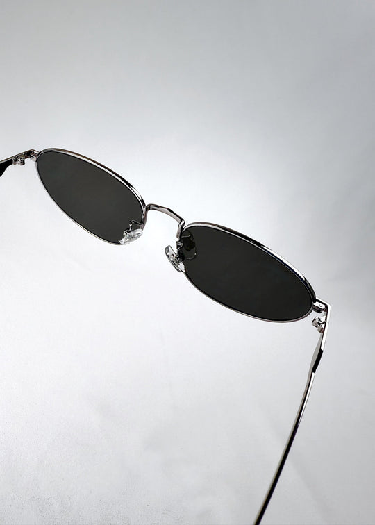 Closeup of Lunaris - Moonlit Silver sunglasses frame, highlighting the metal texture and clean lens rim. 