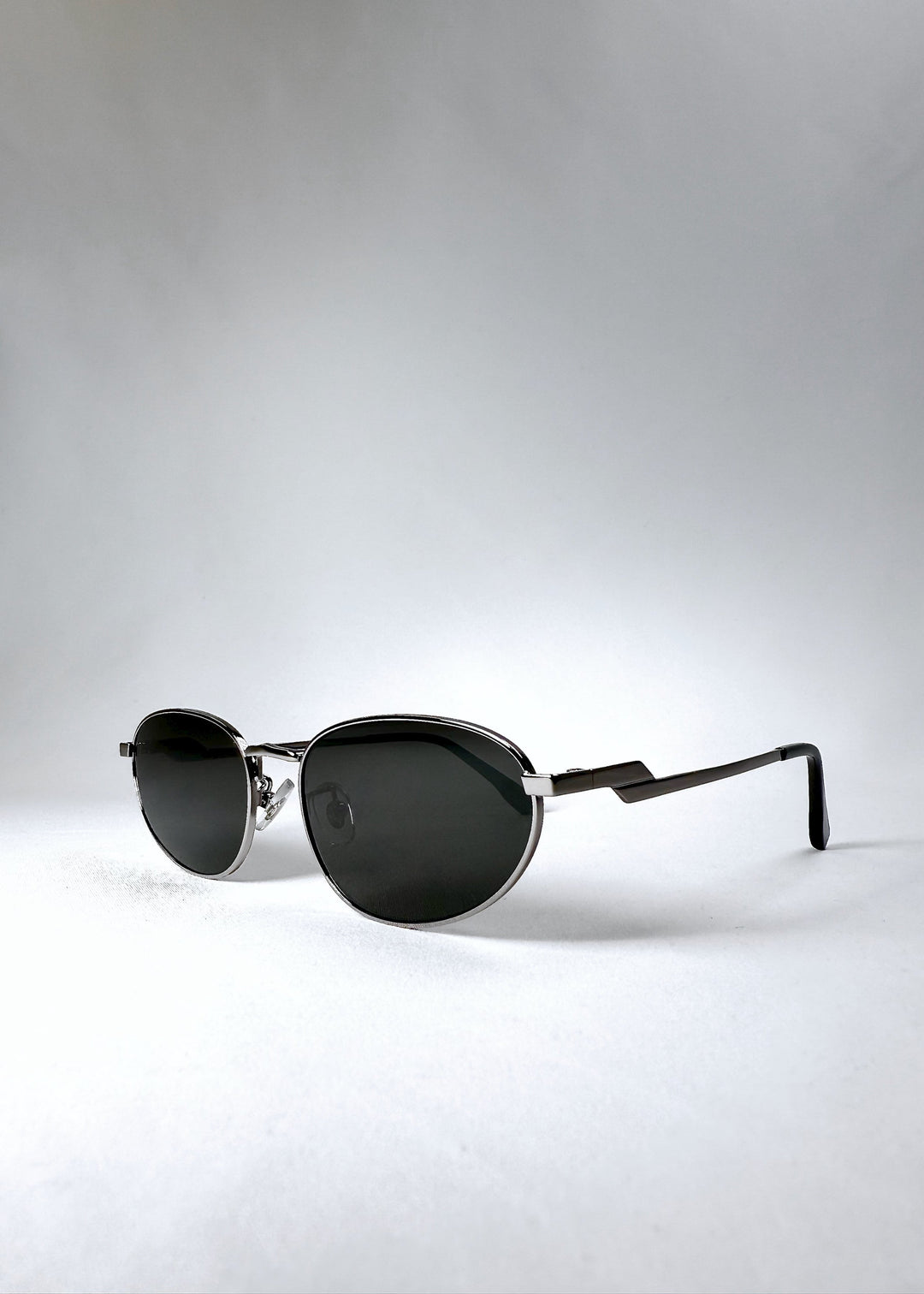 Front angle view of Lunaris - Moonlit Silver sunglasses, highlighting the soft metallic sheen and ergonomic curve. 