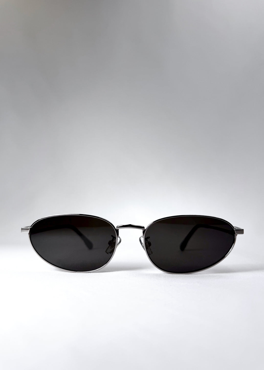 Front view of Lunaris - Moonlit Silver sunglasses, showcasing its shiny silver aviator frame and neutral grey lenses. 
