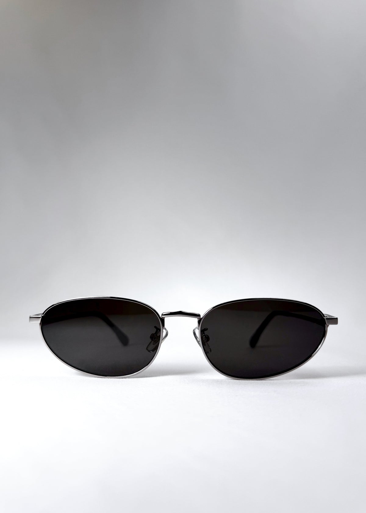 Front view of Lunaris - Moonlit Silver sunglasses, showcasing its shiny silver aviator frame and neutral grey lenses.