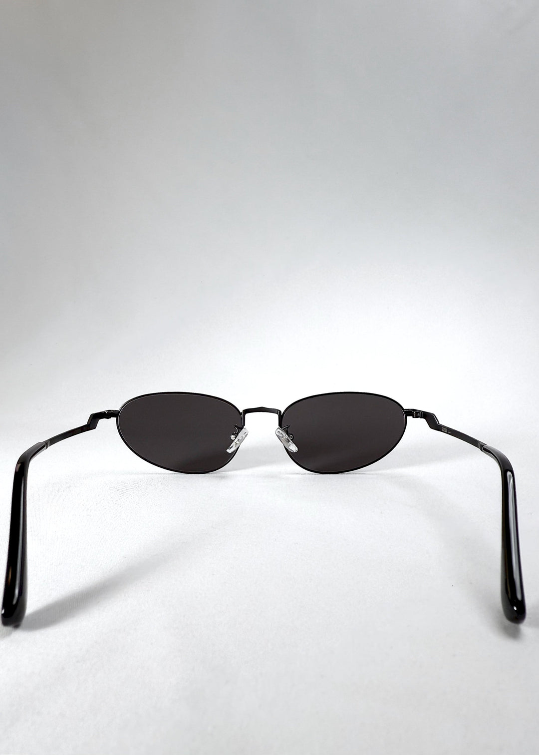 Back view of Lunaris - Shadow Black sunglasses highlighting the adjustable nose pads and ergonomic arm design. 