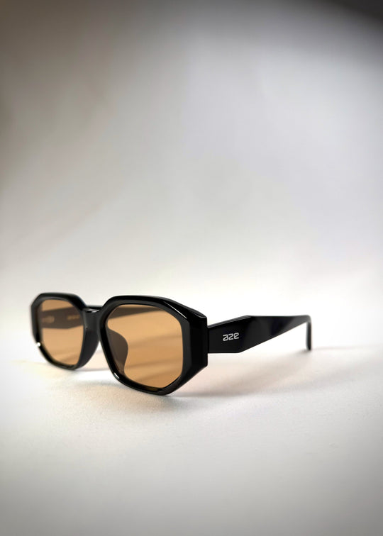 Three-quarter side view of Lyra sunglasses in Amber, featuring a glossy black acetate frame with amber-tinted lenses, showing the frame contours and lens tint. 