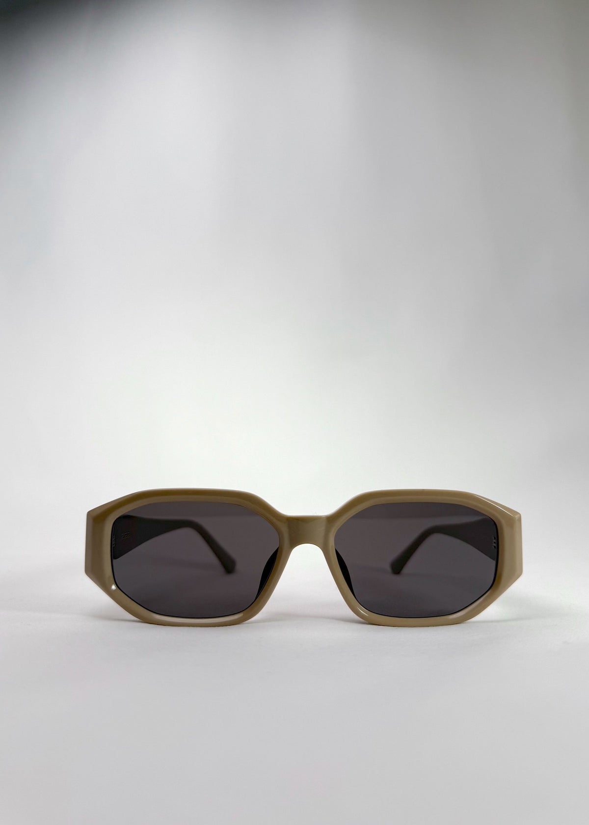 Front view of Lyra sunglasses in Creamy Beige, featuring a sculpted acetate frame, angular lens shape, and UV400 lenses, showing the full front silhouette.