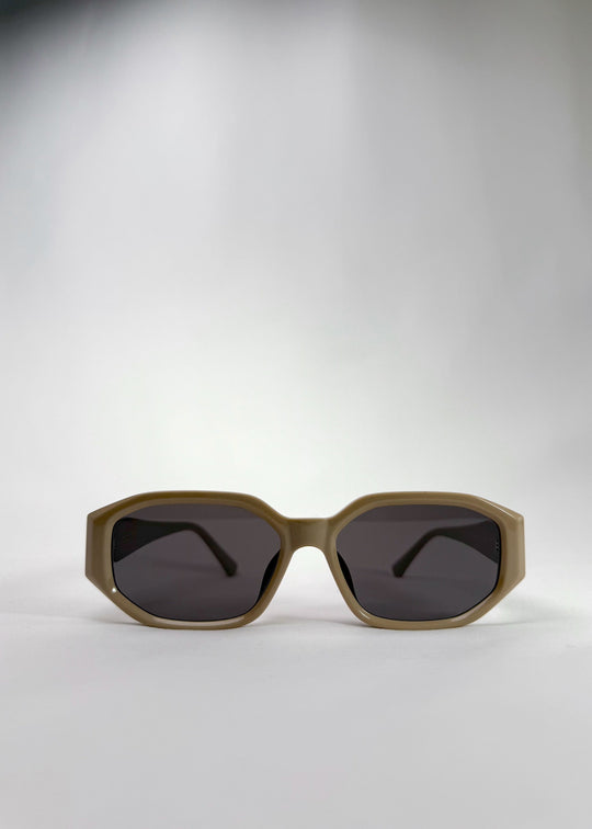 Front view of Lyra sunglasses in Creamy Beige, featuring a sculpted acetate frame, angular lens shape, and UV400 lenses, showing the full front silhouette. 