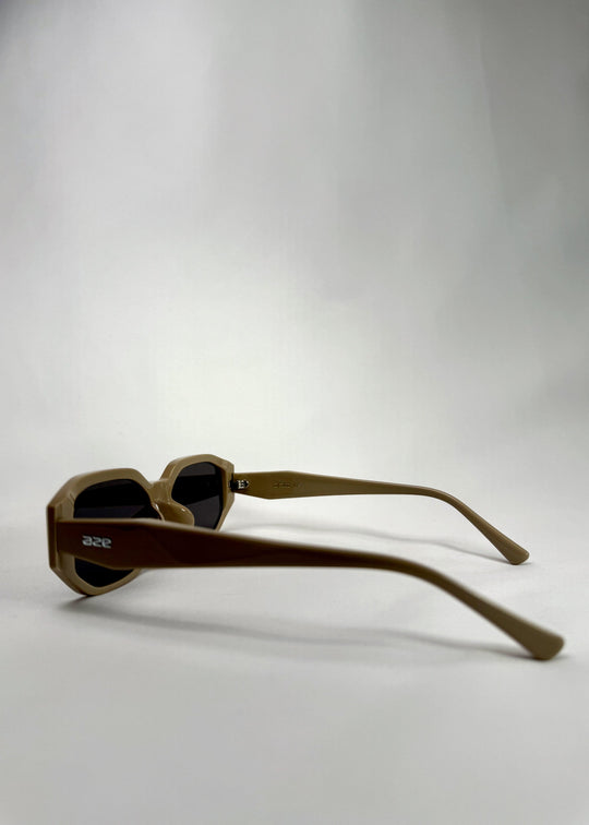 Side-angle view of Lyra sunglasses in Creamy Beige, featuring a sculpted acetate frame, angular lens shape, and UV400 lenses, showing the lens shape and temple profile. 