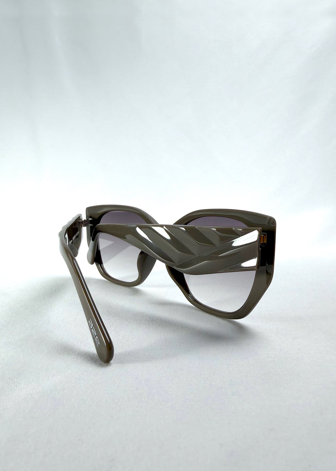 Back-angle view of Marlowe sunglasses in Graphite Haze, featuring grey-brown acetate frame and smoky lenses, showing the back structure and temple alignment.