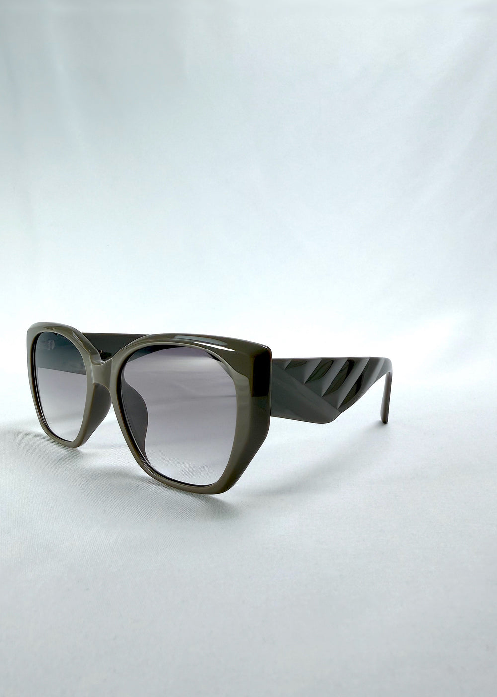 Three-quarter front view of Marlowe sunglasses in Graphite Haze, featuring grey-brown acetate frame and smoky lenses, showing the front shape and temple profile.