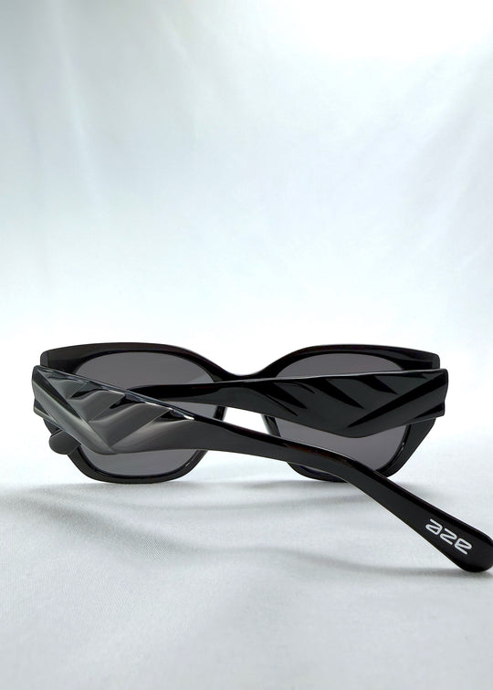 Folded view of Marlowe sunglasses in Obsidian Black, featuring glossy black acetate frame and dark lenses, showing the folded temples and frame profile.