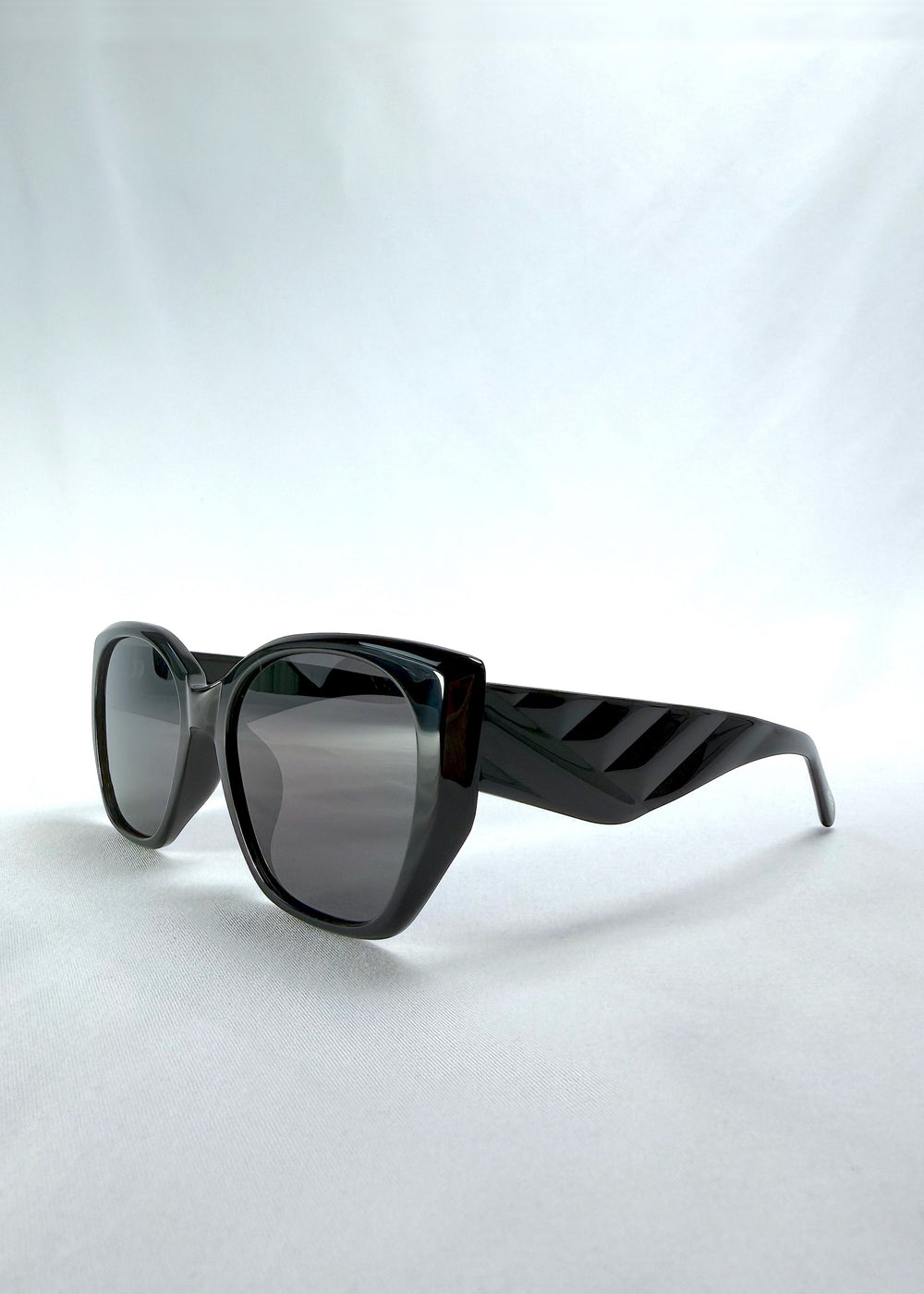 Three-quarter front view of Marlowe sunglasses in Obsidian Black, featuring glossy black acetate frame and dark lenses, showing the front shape and temple profile.
