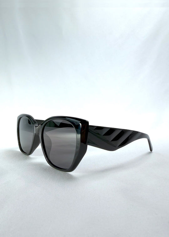 Three-quarter front view of Marlowe sunglasses in Obsidian Black, featuring glossy black acetate frame and dark lenses, showing the front shape and temple profile.