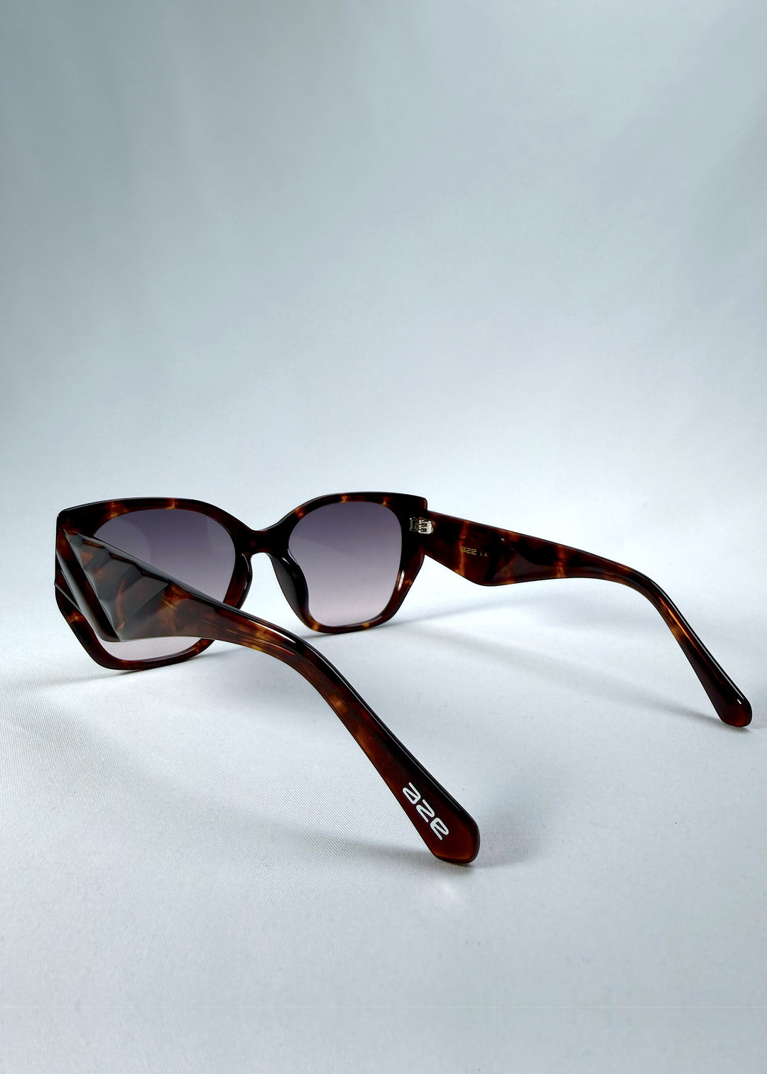 Back-angle view of Marlowe sunglasses in Tortoiseshell, featuring a sculpted tortoiseshell acetate frame and smoky gradient lenses, showing the rear frame structure and temple alignment.