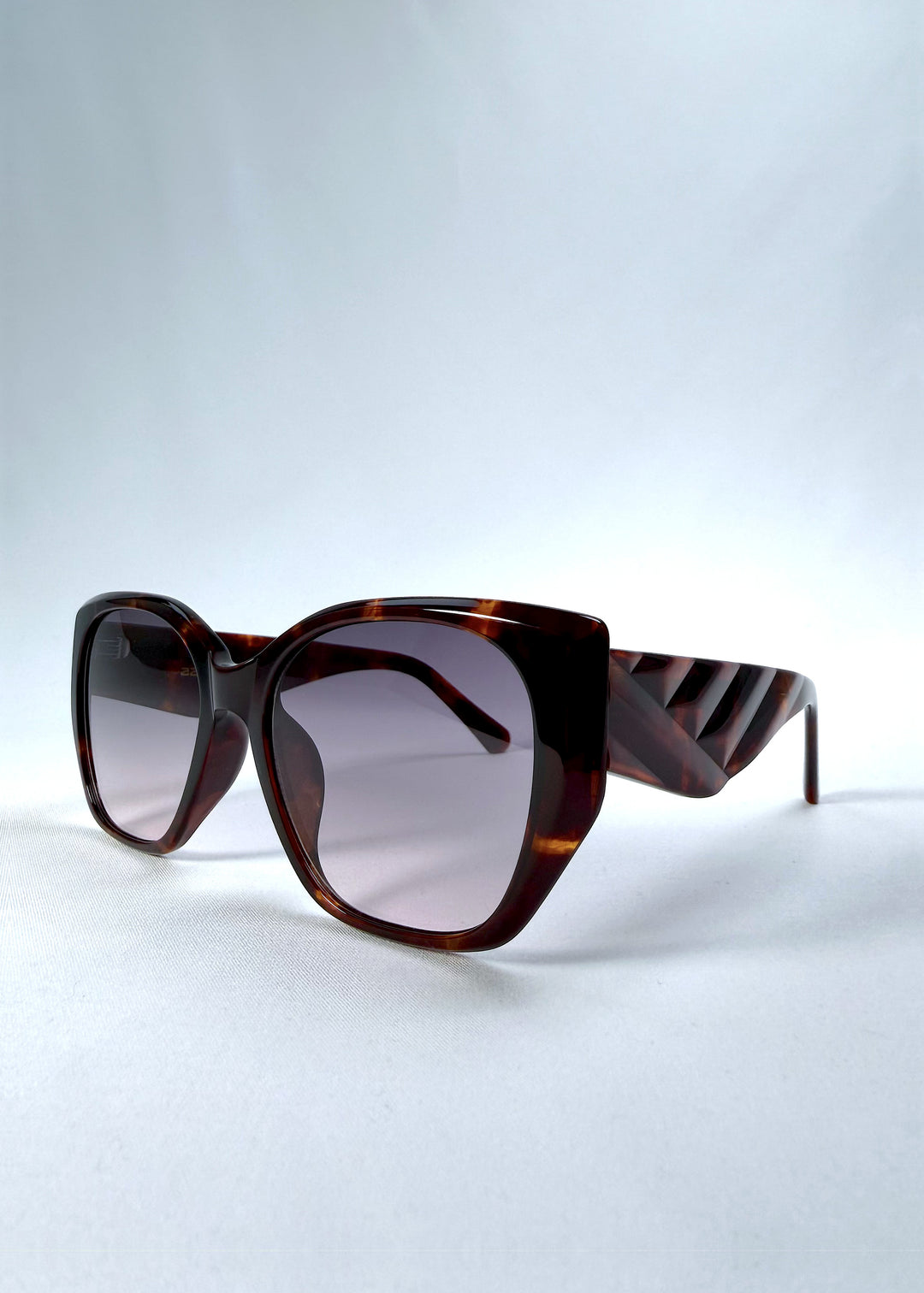 Three-quarter front view of Marlowe sunglasses in Tortoiseshell, featuring a sculpted tortoiseshell acetate frame and smoky gradient lenses, showing the frame shape and temple profile.