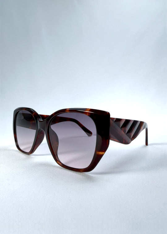 Three-quarter front view of Marlowe sunglasses in Tortoiseshell, featuring a sculpted tortoiseshell acetate frame and smoky gradient lenses, showing the frame shape and temple profile.