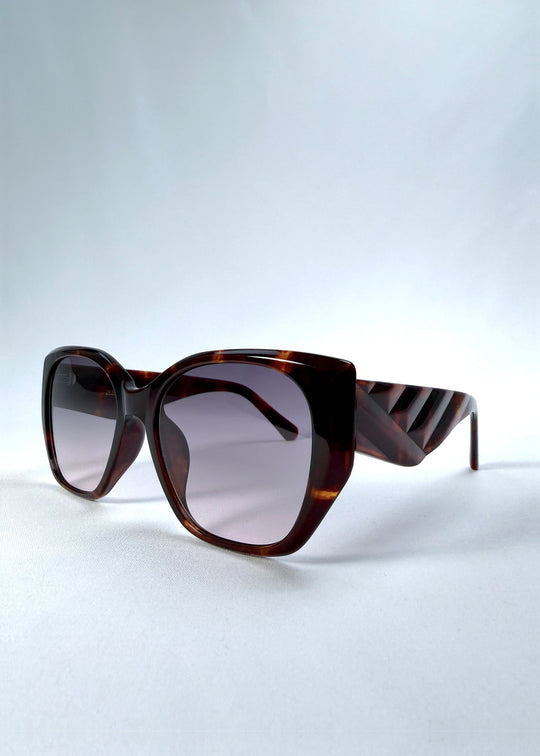 Three-quarter front view of Marlowe sunglasses in Tortoiseshell, featuring a sculpted tortoiseshell acetate frame and smoky gradient lenses, showing the frame shape and temple profile. 