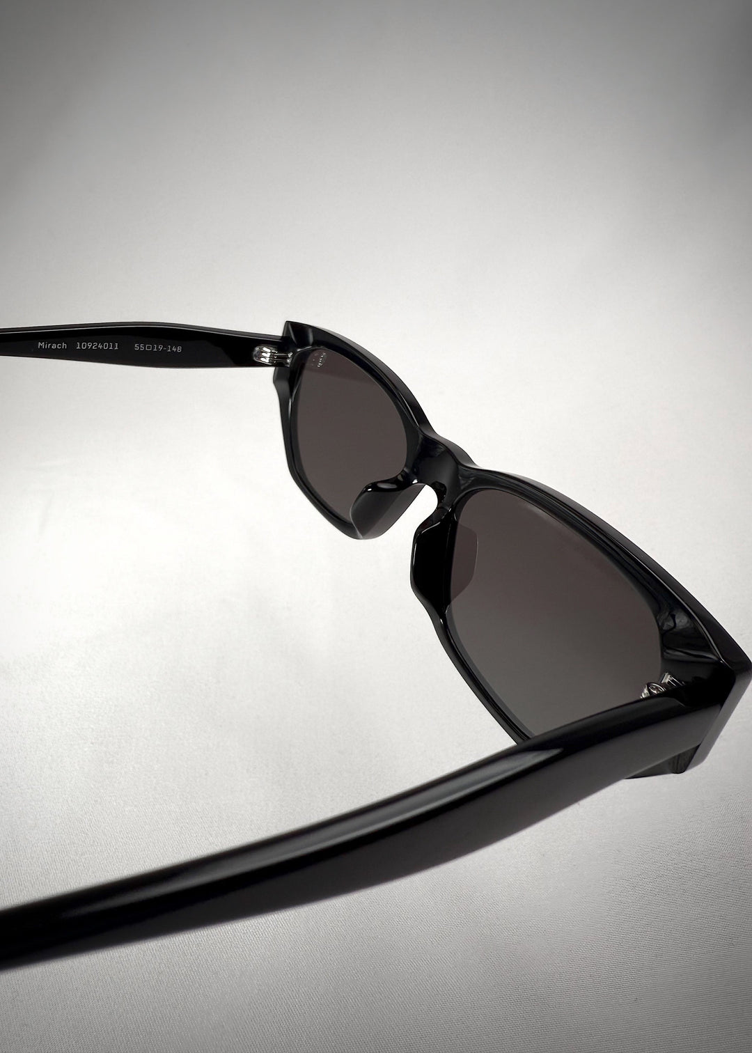 Back-angle view of Mirach sunglasses in Black, featuring a glossy black acetate frame and gray UV400 lenses, showing the back structure and temple alignment. 