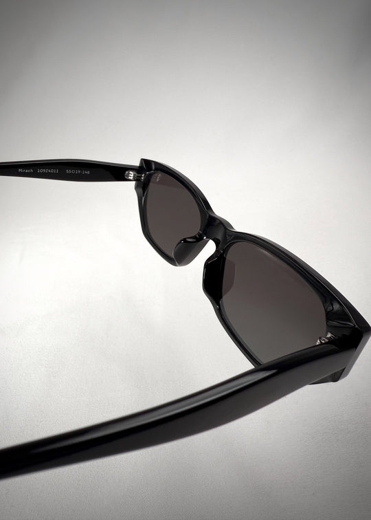 Back-angle view of Mirach sunglasses in Black, featuring a glossy black acetate frame and gray UV400 lenses, showing the back structure and temple alignment. 