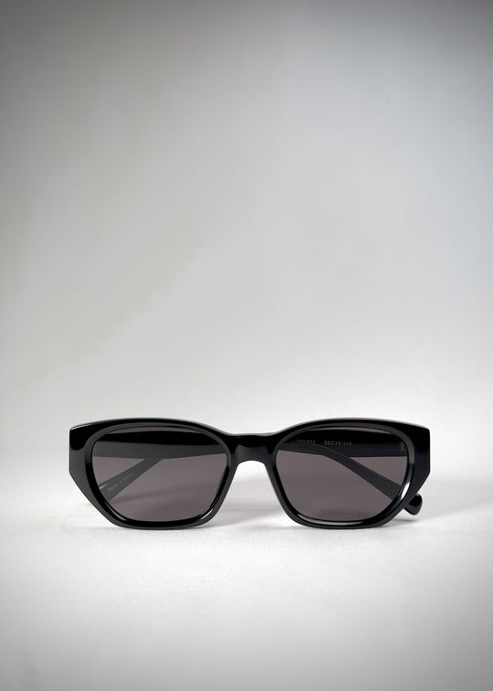 Folded view of Mirach sunglasses in Black, featuring a glossy black acetate frame and gray UV400 lenses, showing the folded temples and frame profile. 
