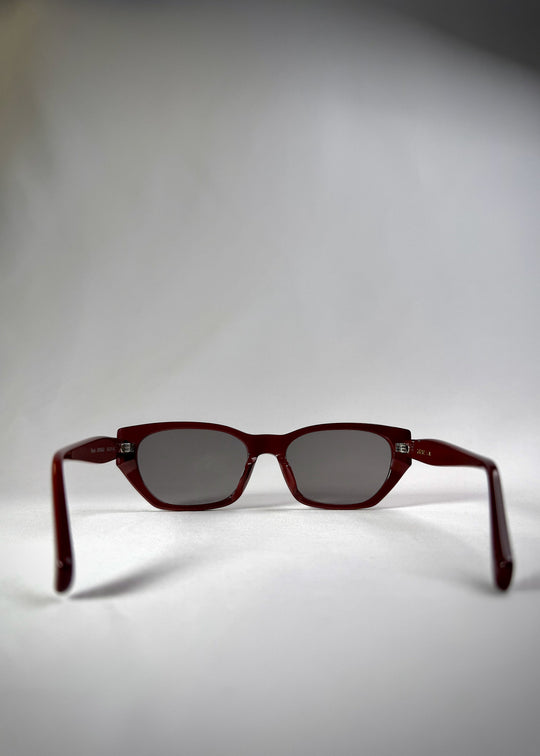 Back view of Mirach sunglasses in Burgundy, featuring a deep burgundy acetate frame and gray UV400 lenses, showing the inside frame and open temples. 