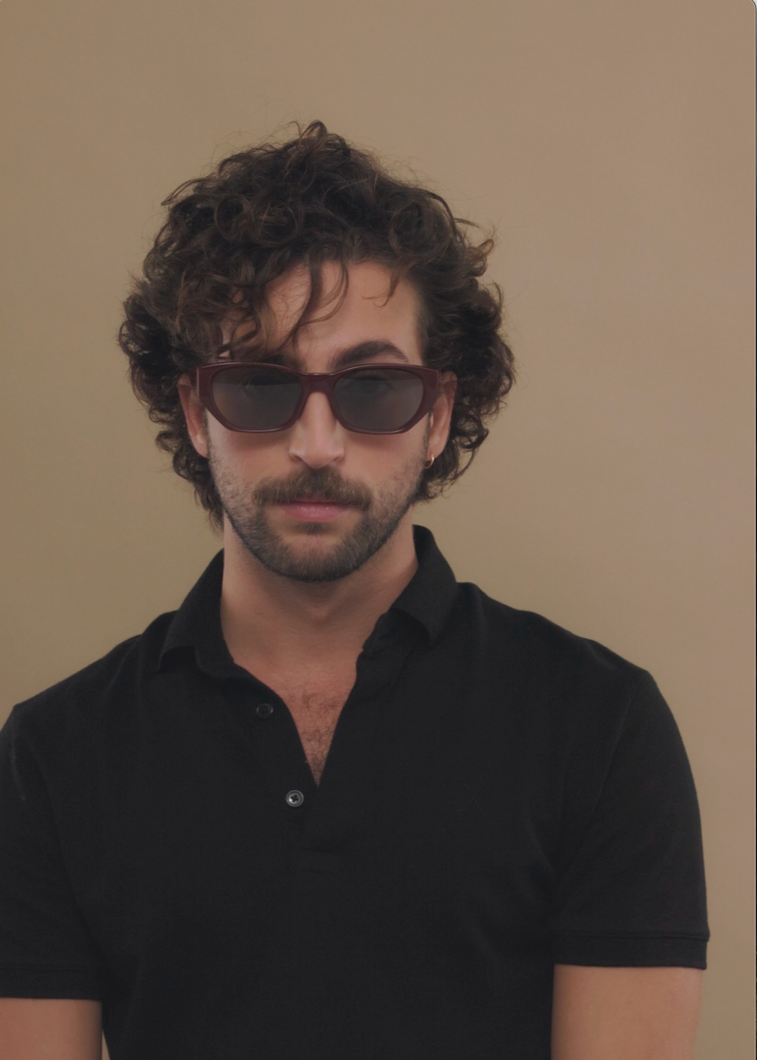 Male model wearing Mirach sunglasses in Burgundy. 