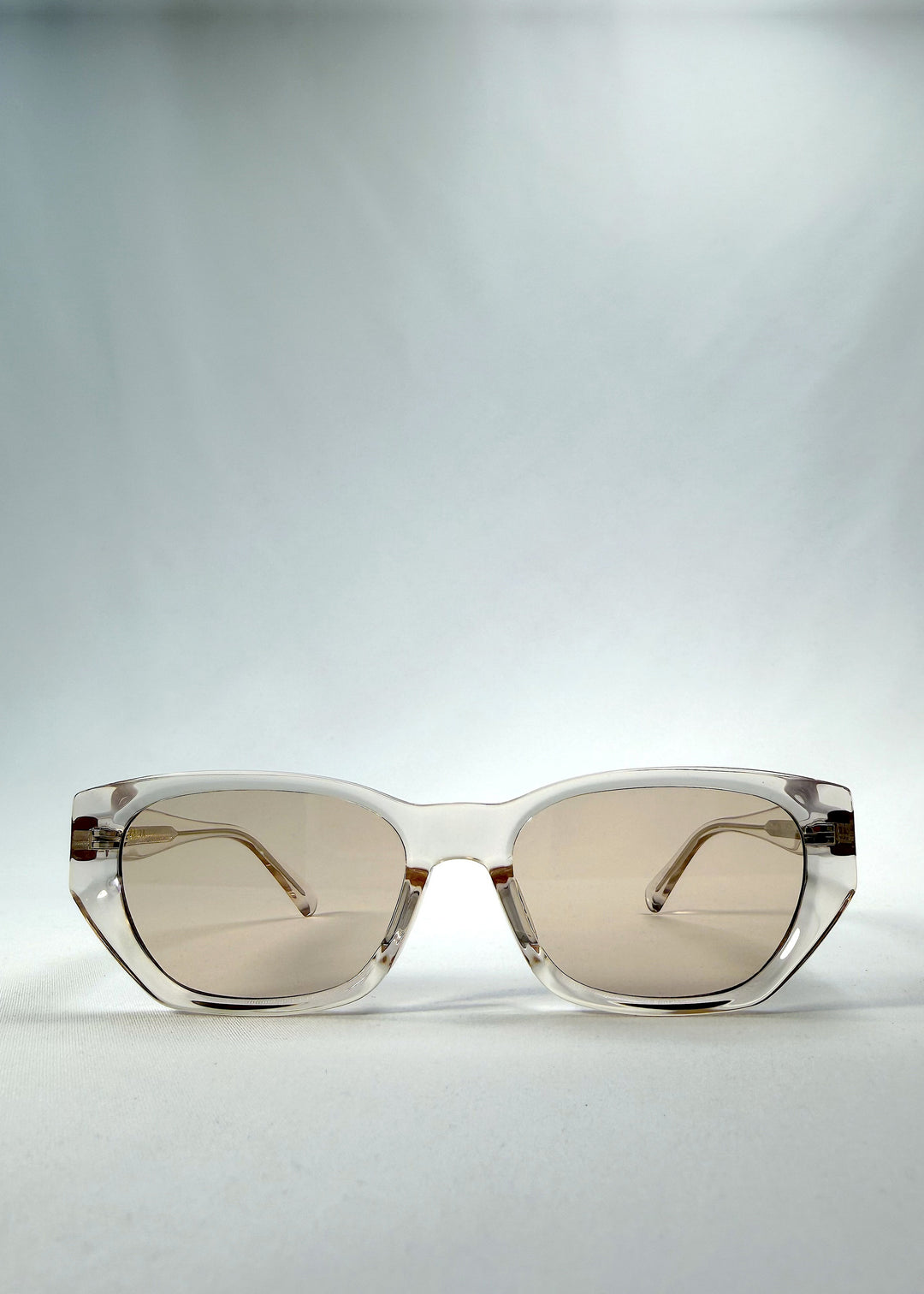 Front view of Mirach sunglasses in Transparent White, featuring crystal-clear acetate frame and tea-tinted lenses, showing the full front silhouette.
